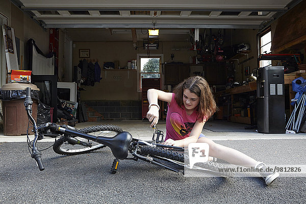 Girl Reparatur Fahrrad vor der Garage