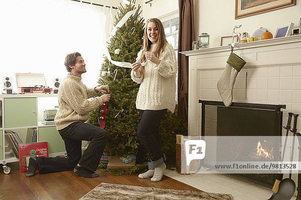 Junges Paar bereitet Dekoration für den Weihnachtsbaum vor