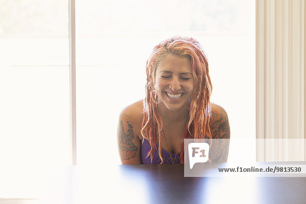 Young woman with pink dreadlocks laughing