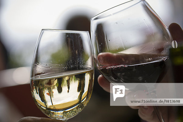 Close up of two wine glasses toasting each other in restaurant