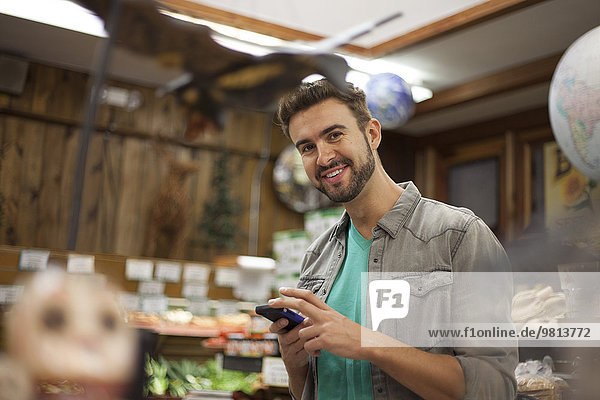Man using smartphone in health food store