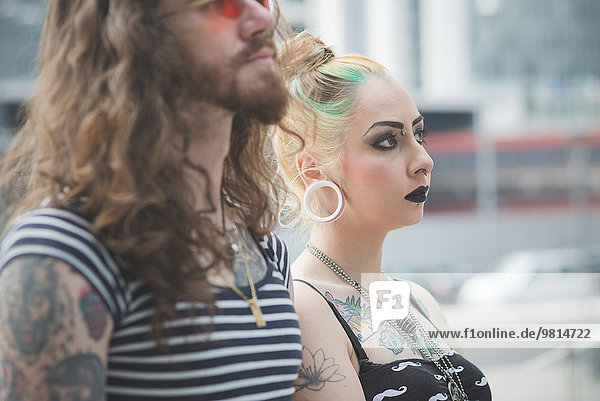 Portrait of punk hippy couple side by side on city street