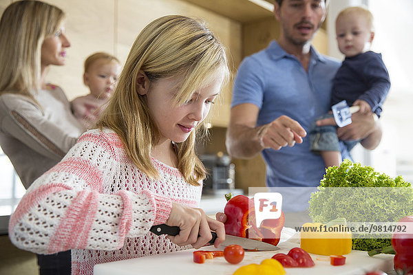 Girl with family preparing peppers on kitchen counter
