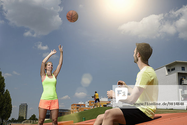 Male and female basketball players practicing in park