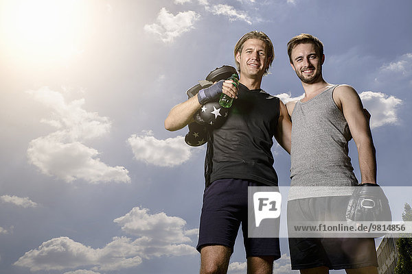 Portrait of male boxer and personal trainer in park