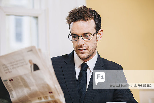 Jungunternehmer beim Lesen der Morgenzeitung zu Hause