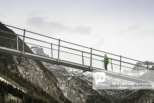Tiefblick auf eine junge Frau beim Wandern auf der Fußgängerbrücke  Holzgau  Tirol  Österreich