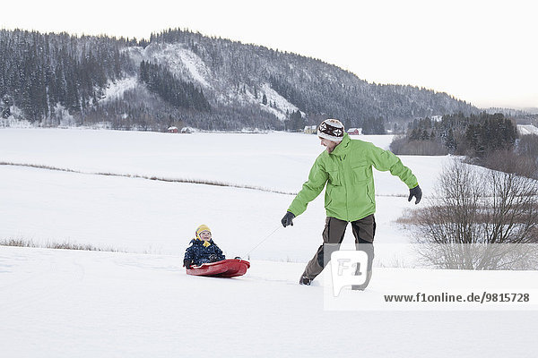 Vater und Sohn spielen im Schnee