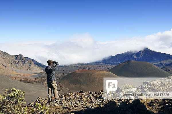 USA  Hawaii  Maui  Haleakala  man taking picture of volcanic landscape with cinder cones