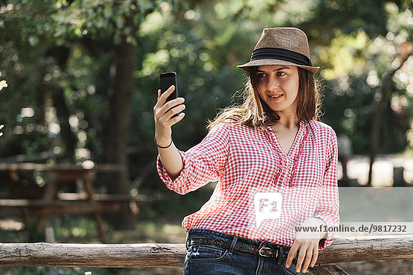 Frau  die einen Selfie mit ihrem Smartphone nimmt