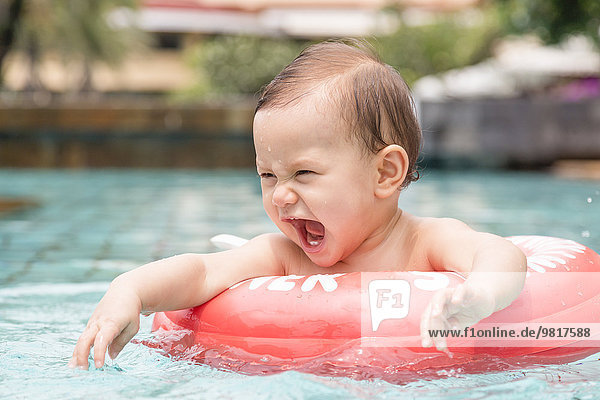 Thailand  schreiendes kleines Mädchen mit schwimmendem Reifen im Schwimmbad