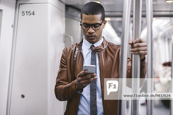 Geschäftsmann mit Smartphone in der U-Bahn