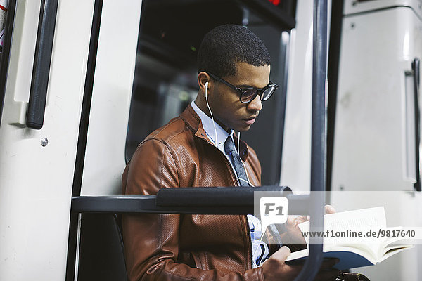 Geschäftsmann liest Buch in der U-Bahn