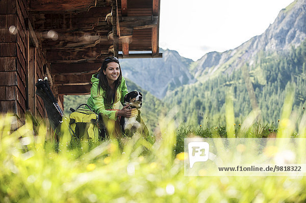 Austria  Altenmarkt-Zauchensee  young woman with dog at alpine cabin