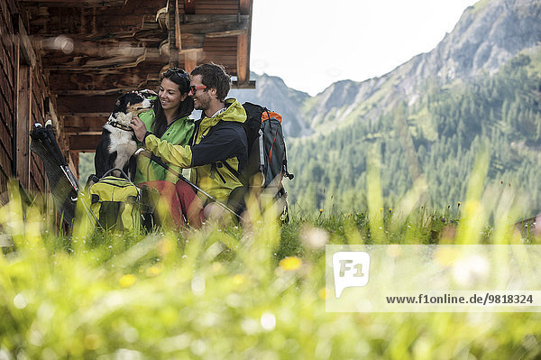 Austria  Altenmarkt-Zauchensee  young couple with dog at alpine cabin
