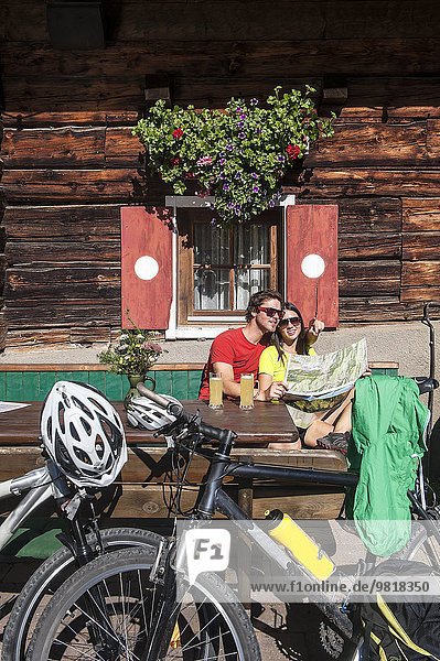 Österreich  Altenmarkt-Zauchensee  junges Paar mit Mountainbikes auf der Hütte