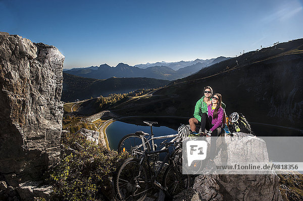 Österreich  Altenmarkt-Zauchensee  junges Paar mit Mountainbikes in den Bergen