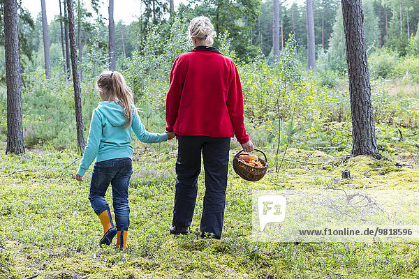 Estland  Mutter und Tochter mit Pilzkorb im Wald