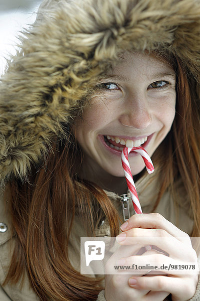 Portrait of happy girl holding candy cane
