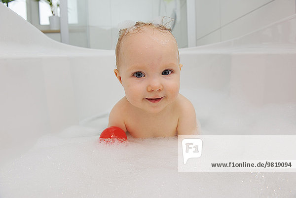 Portrait of smiling baby girl in a bathtub