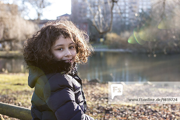 Porträt eines lächelnden Mädchens im Park an einem Wintertag