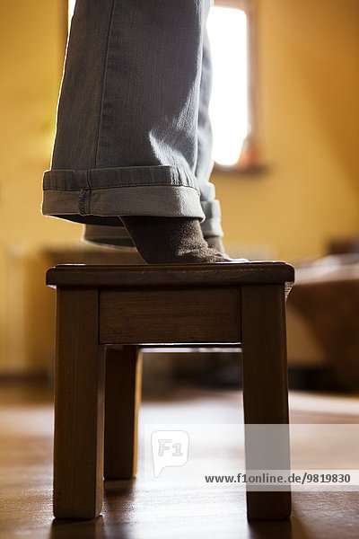Legs of a woman standing on stool