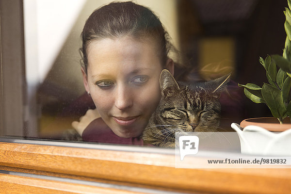 Frau und Katze am Fenster