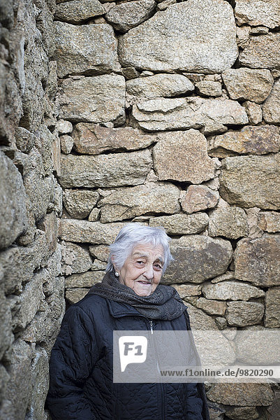 Spanien  Galizien  Ferrol  alte Frau an der Steinmauer