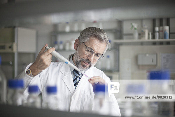 Wissenschaftler gießt Flüssigkeit in ein Reagenzglas