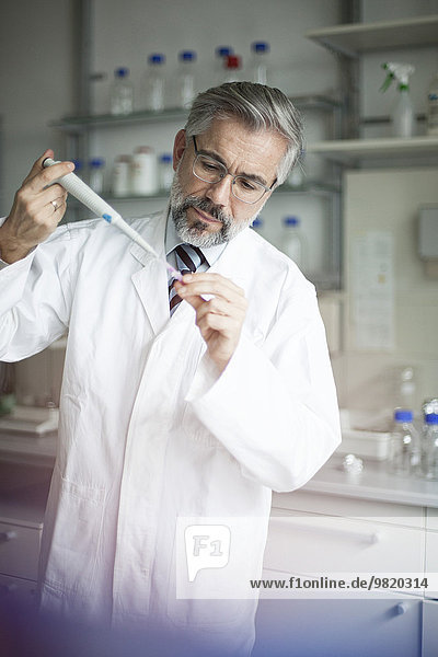 Wissenschaftler gießt Flüssigkeit in ein Reagenzglas