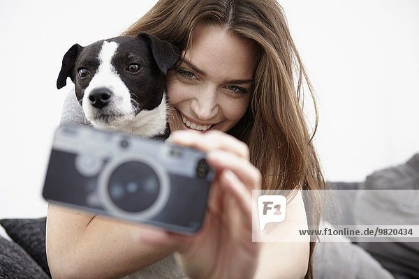 Junge Frau nimmt Selfie mit Hund