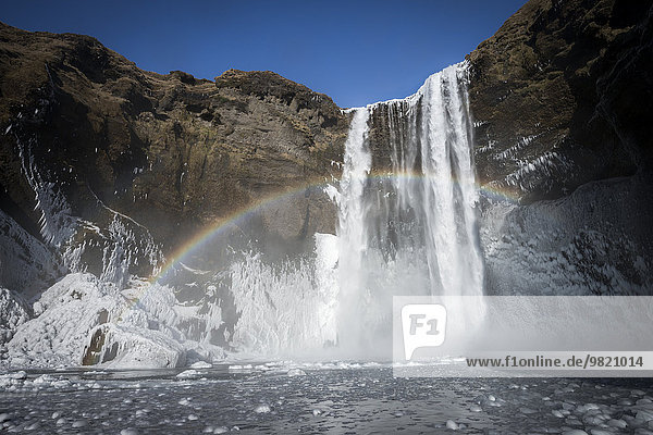 Island  Skogafoss Wasserfall im Winter  Regenbogen