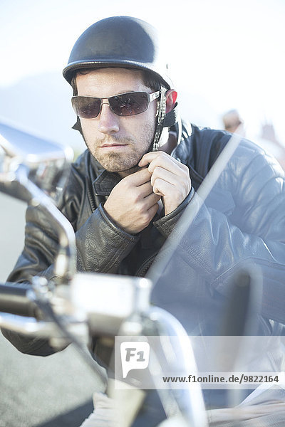 Mann auf Motorrad mit Helmhalterung