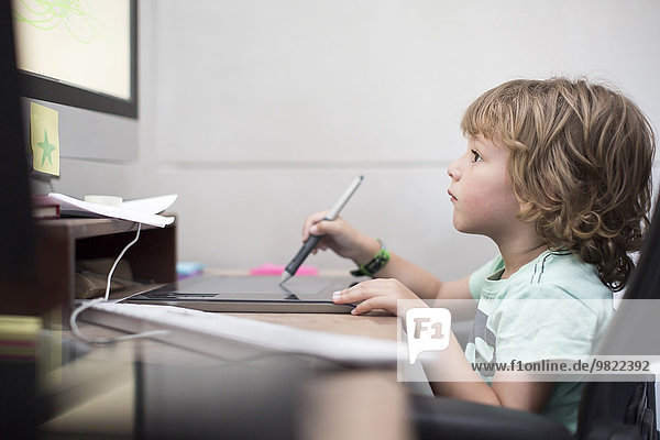 Little boy playing at computer