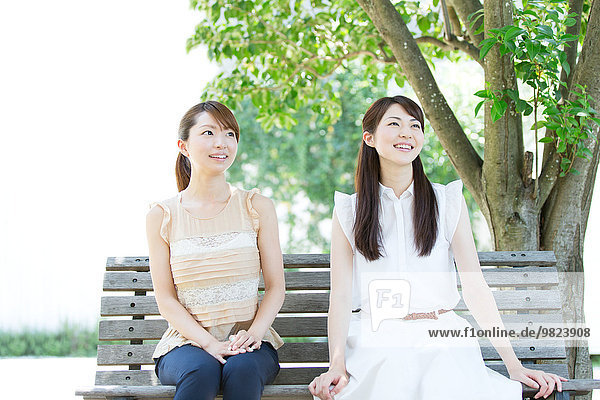 Attractive young girls sitting in a park