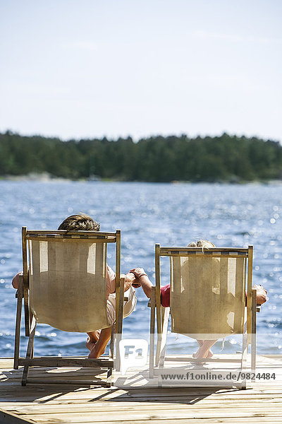 Couple on deckchairs at lake