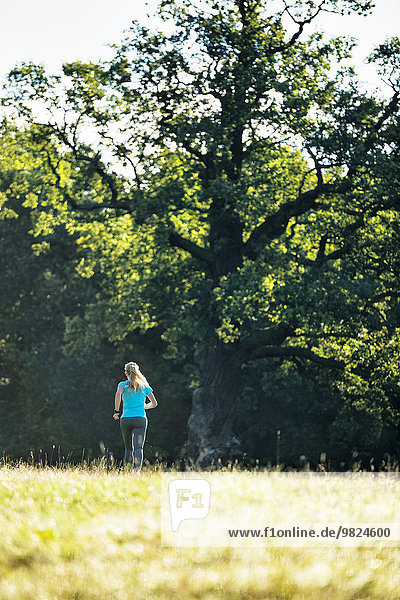 Woman jogging through meadow