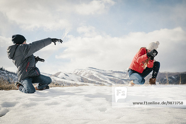 A snowball fight between a brother and sister.