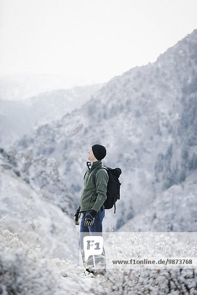 A man hiking through the mountains carrying a rucksack.