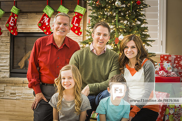 Caucasian multi-generation family smiling in living room at Christmas