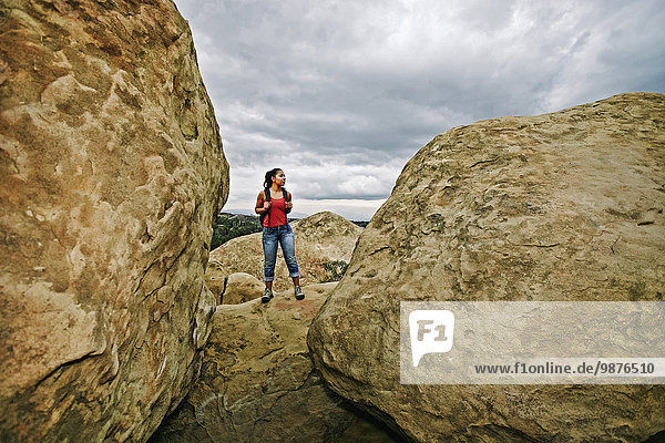 Hispanic woman hiking on rock formations