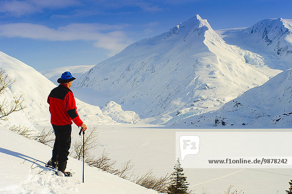Man Snowshoeing In Portage Valley With Frozen Portage Lake In The Background  Southcentral Alaska