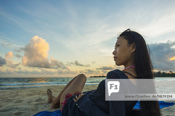 junge Frau junge Frauen Pose liegend liegen liegt liegendes liegender liegende daliegen Strand Sonnenuntergang