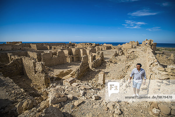 'Man walking through old fortress near Duba; Saudi Arabia'