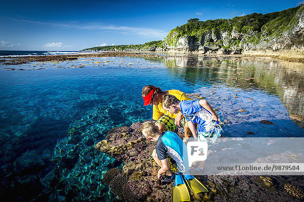 'Family exploring the reef that rings Niue Island; Niue'