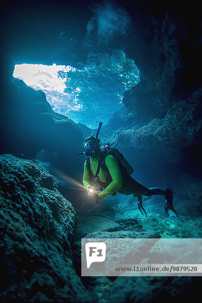 'Diving into one of the underwater caves that surround Niue; Niue Island'