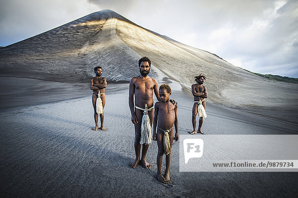 'A group of ni-Vanuatu men from the local village gather at the base of Yasur Volcano; Tanna Island  Vanuatu'