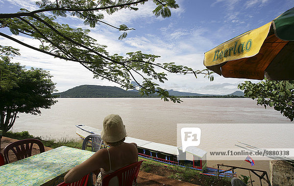'Tourist in riverside cafe along the Mekong river; Pakse  Champasak Province  Laos'