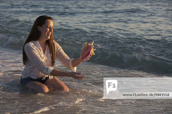 junge Frau junge Frauen Sonnenuntergang Ozean Seemuschel Entdeckung Verbindung