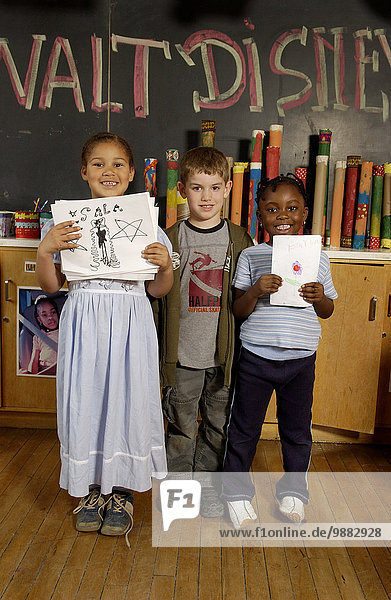 Four To Seven Year Old Kids  Showing Artwork In A Classroom